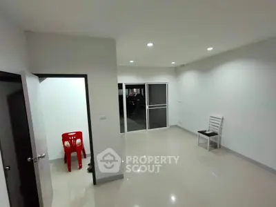 Spacious unfurnished room with glossy tiled floors and bright lighting, ideal for customization.