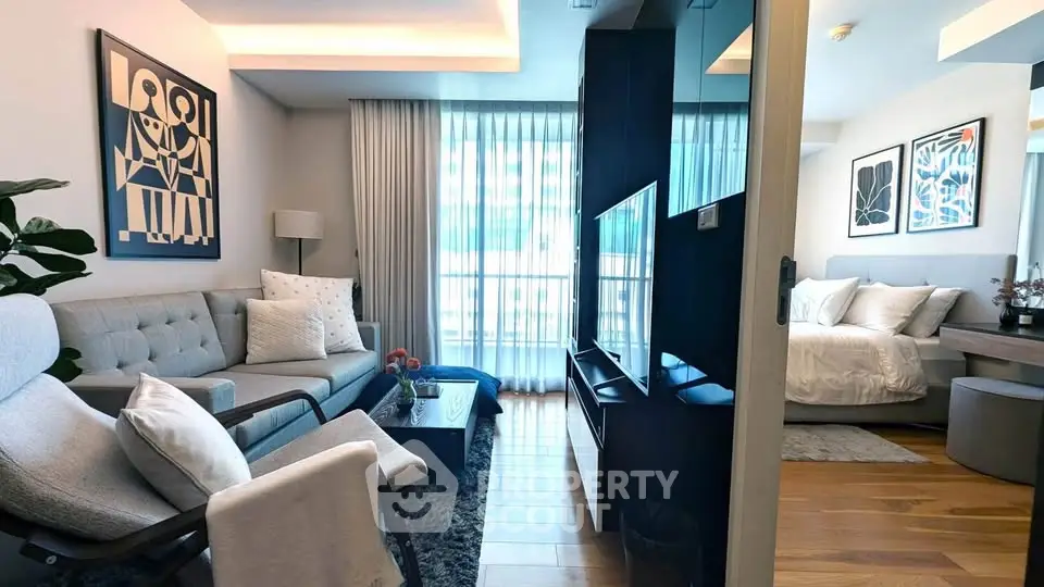 Modern open-plan living room with stylish decor and cozy bedroom view