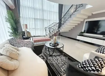 Luxurious modern living room with elegant staircase and large windows