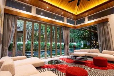 Luxurious modern living room with large windows and garden view, featuring elegant furniture and stylish decor.