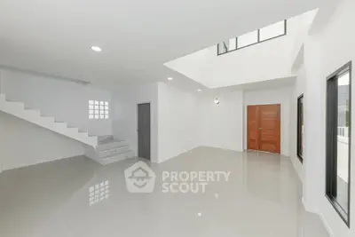 Spacious modern living room with high ceilings and elegant staircase