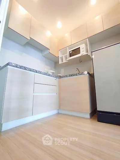 Modern kitchen with light wood cabinets and sleek appliances