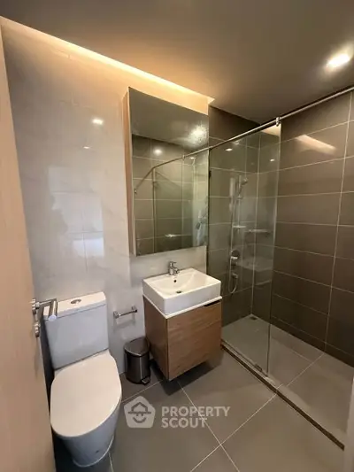Modern bathroom with sleek design featuring glass shower and stylish vanity.