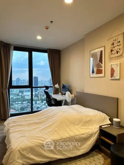 Modern bedroom with city view, featuring stylish decor and a cozy workspace.