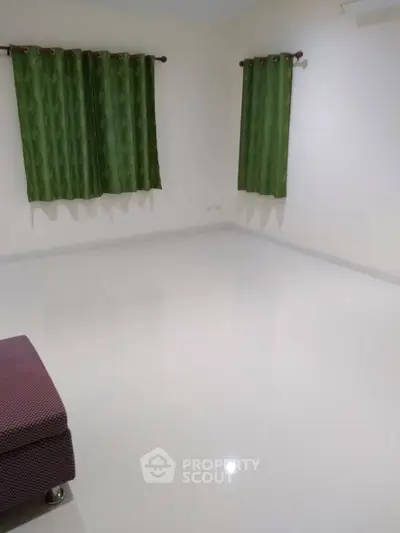 Spacious empty room with glossy white floor and green curtains