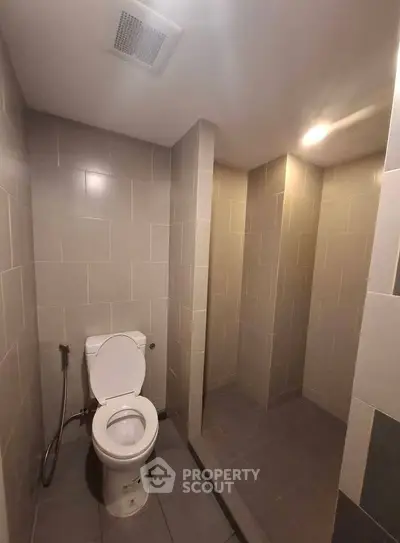Modern bathroom with sleek tile design and open shower area.