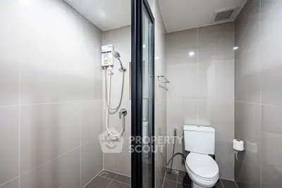 Modern bathroom with sleek shower and toilet in minimalist design.