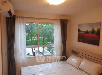 Cozy bedroom with large window and scenic view, perfect for relaxation.