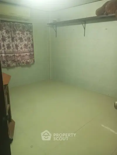 Spacious empty room with tiled floor and floral curtains, ideal for customization.