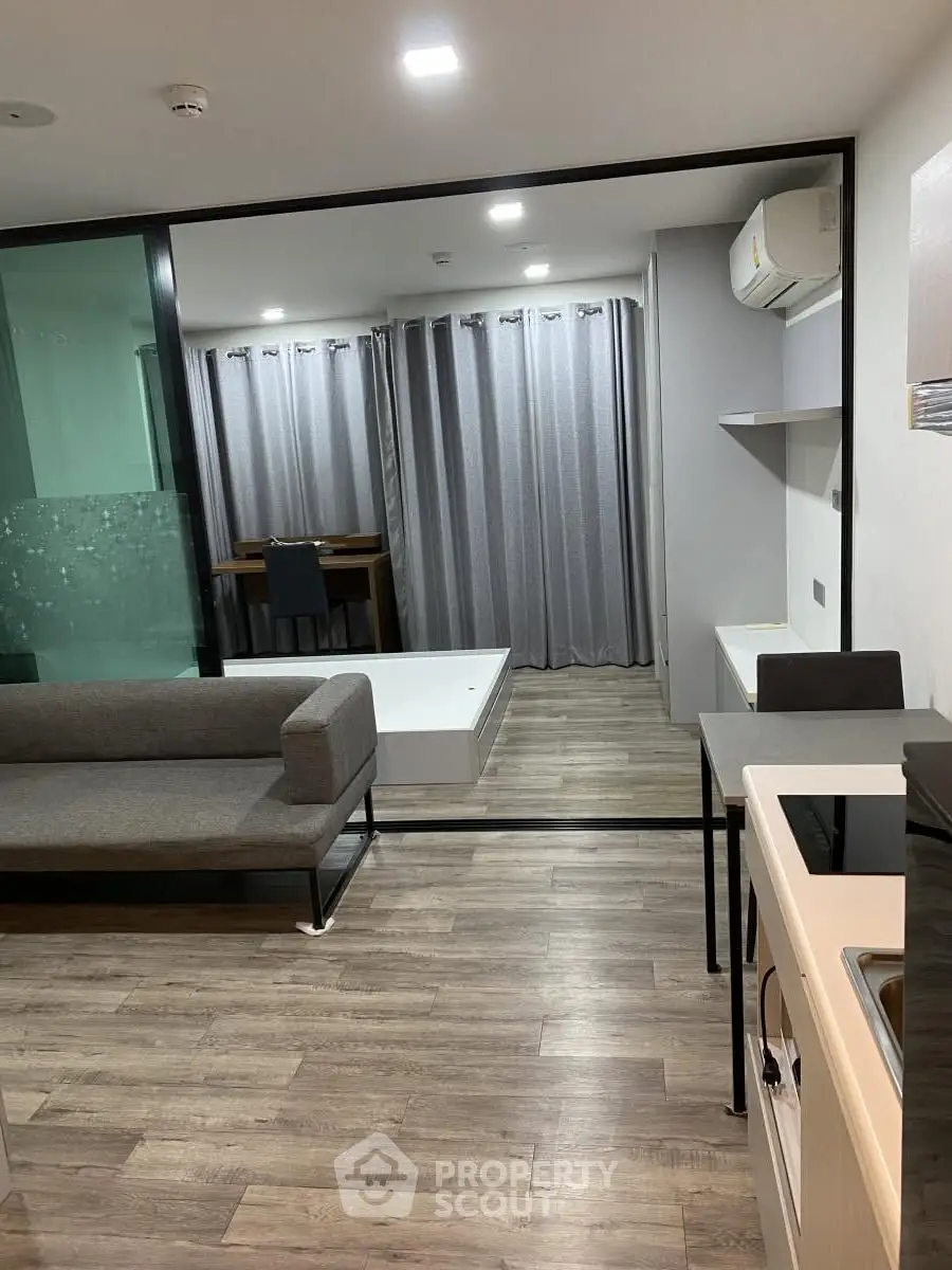 Modern studio apartment with sleek design and open layout, featuring a cozy living area and stylish kitchen.