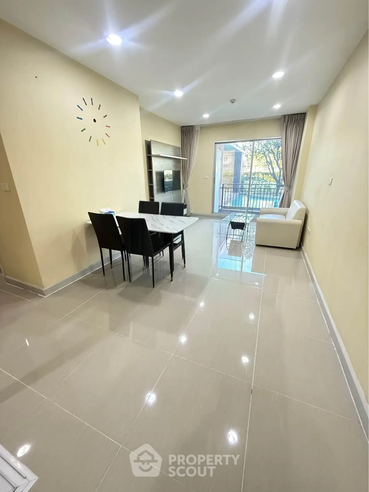 Spacious modern living room with dining area and large windows offering natural light.