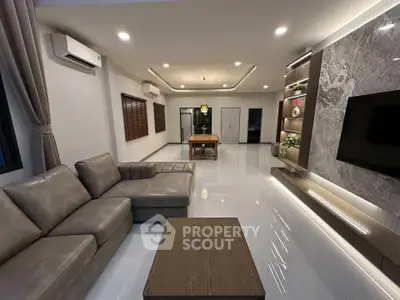 Luxurious modern living room with sleek design and spacious layout, featuring elegant furniture and ambient lighting.