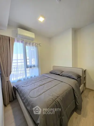 Cozy bedroom with natural light and modern furnishings in a stylish apartment.