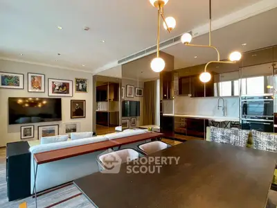 Modern living room with open kitchen, stylish lighting, and elegant decor