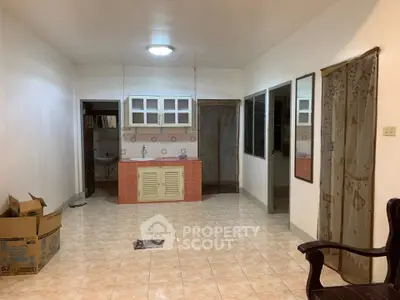 Spacious living area with tiled floor and compact kitchen setup, ideal for cozy urban living.