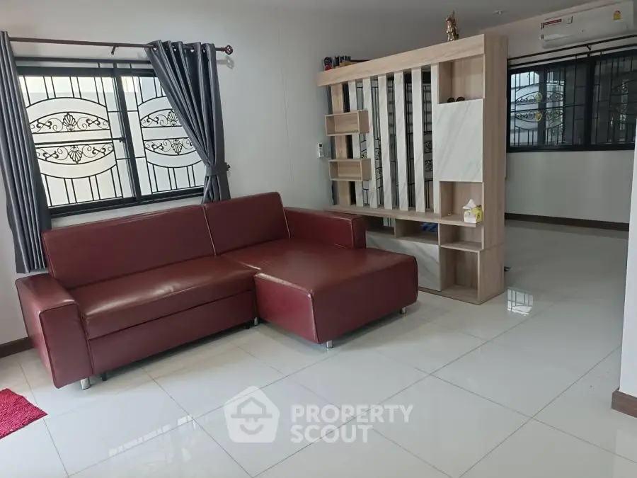 Spacious living room with modern red sectional sofa and stylish partition.