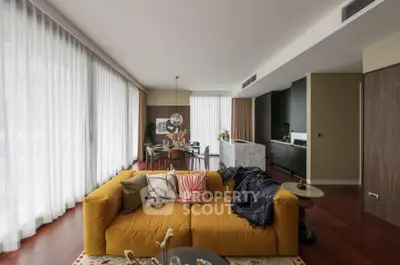 Spacious modern living room with stylish decor and large windows in a luxury apartment.