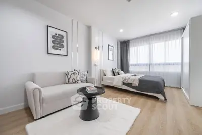 Modern studio apartment with cozy living area and stylish bedroom, featuring elegant decor and natural light.