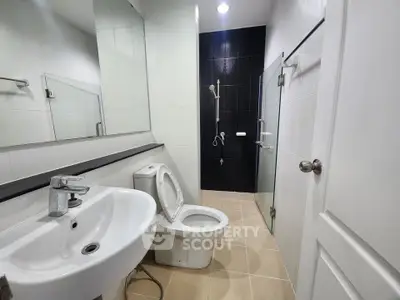 Modern bathroom with sleek fixtures and glass shower enclosure.