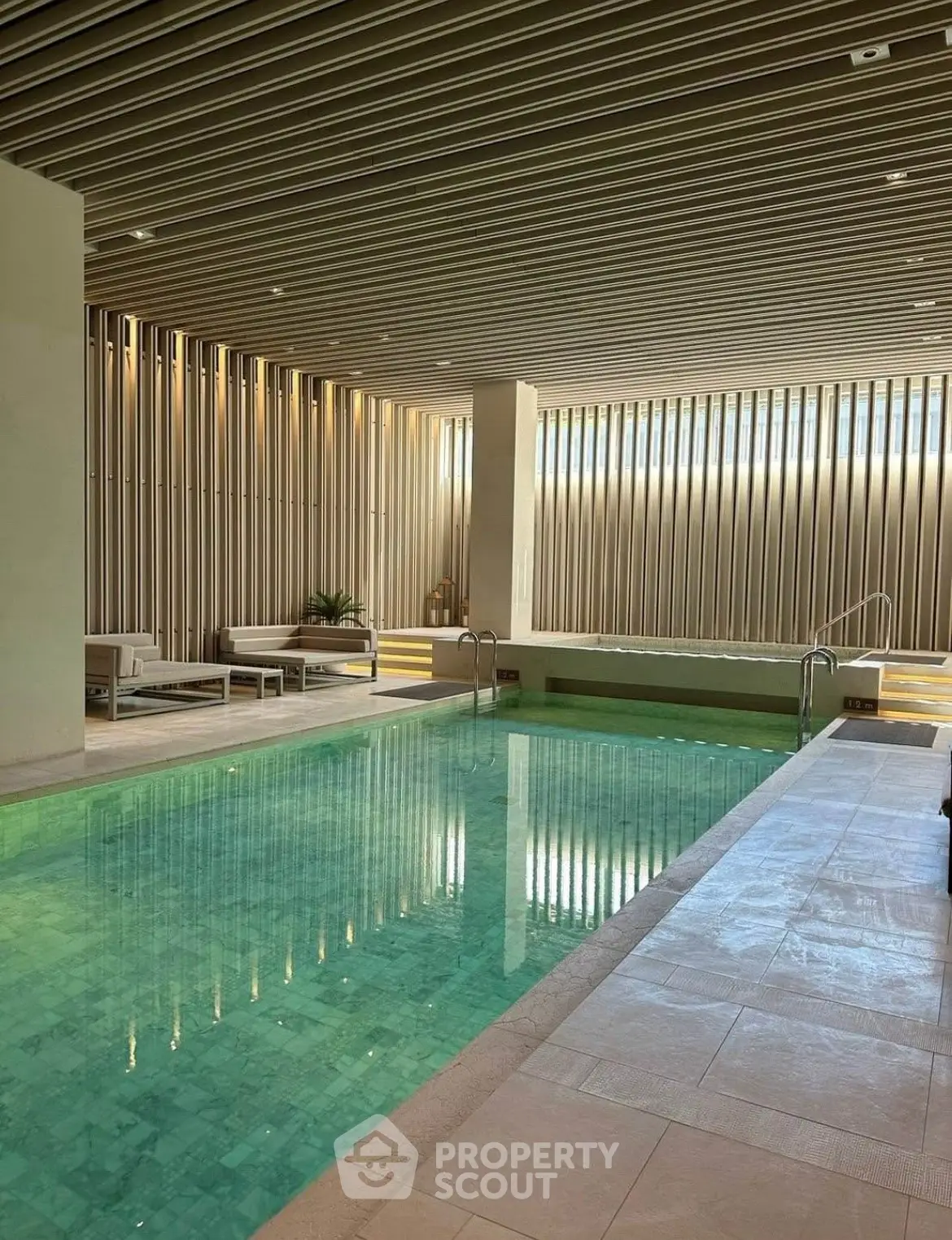 Luxurious indoor pool with modern design and elegant seating area, perfect for relaxation and leisure.