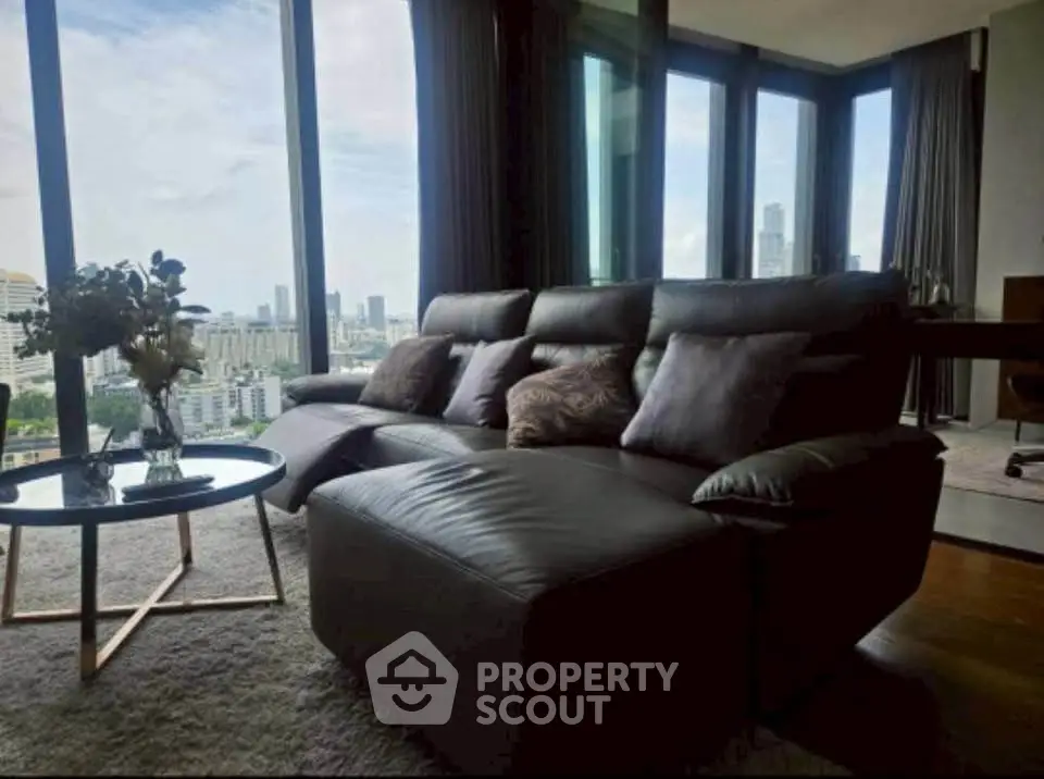 Luxurious living room with panoramic city views and modern furnishings.