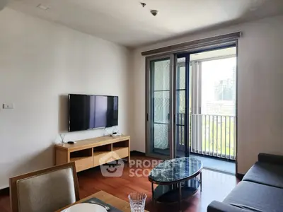 Modern living room with balcony view, featuring sleek furniture and natural light.