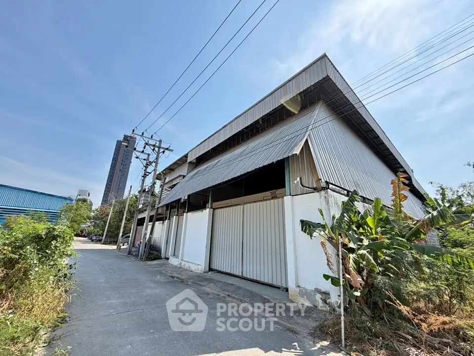 Spacious industrial warehouse with high ceilings and large doors, ideal for storage or manufacturing.