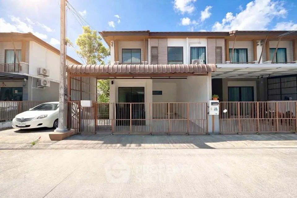 Charming two-story townhouse with modern facade and spacious driveway in a serene neighborhood.
