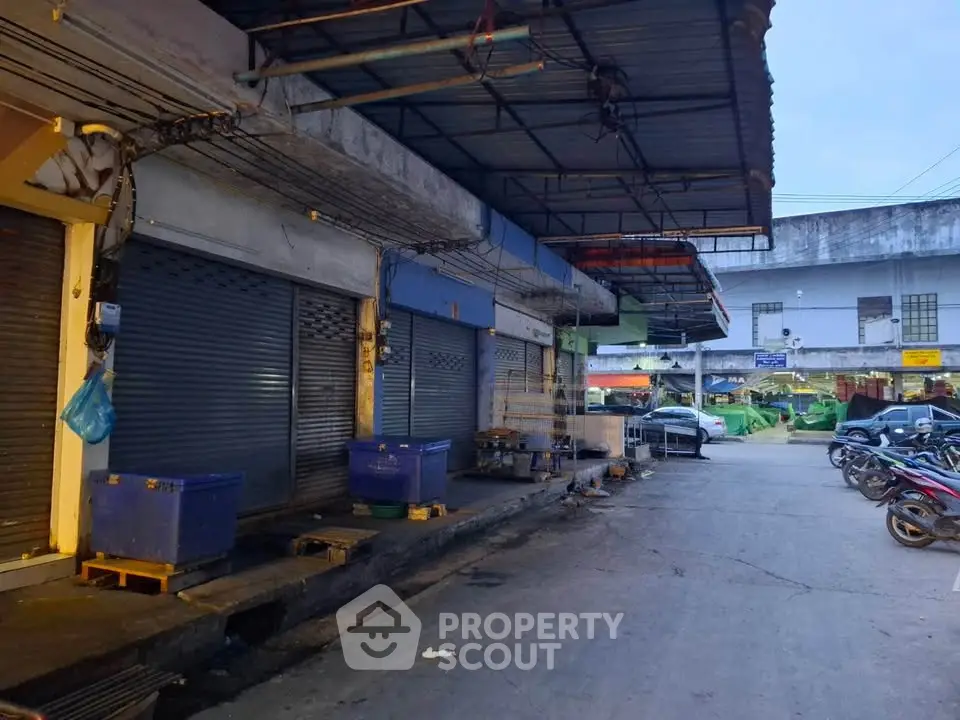 Commercial property exterior with closed shutters and parking area, ideal for business opportunities.