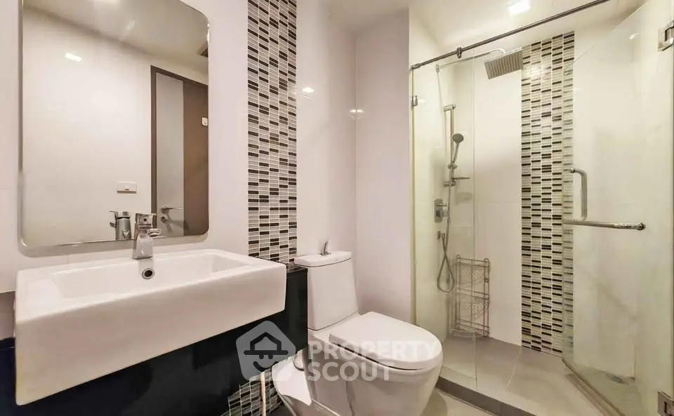Modern bathroom with sleek design, glass shower, and stylish tiles.