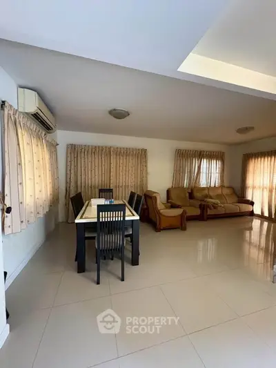 Spacious living room with elegant dining area and cozy seating, perfect for family gatherings.