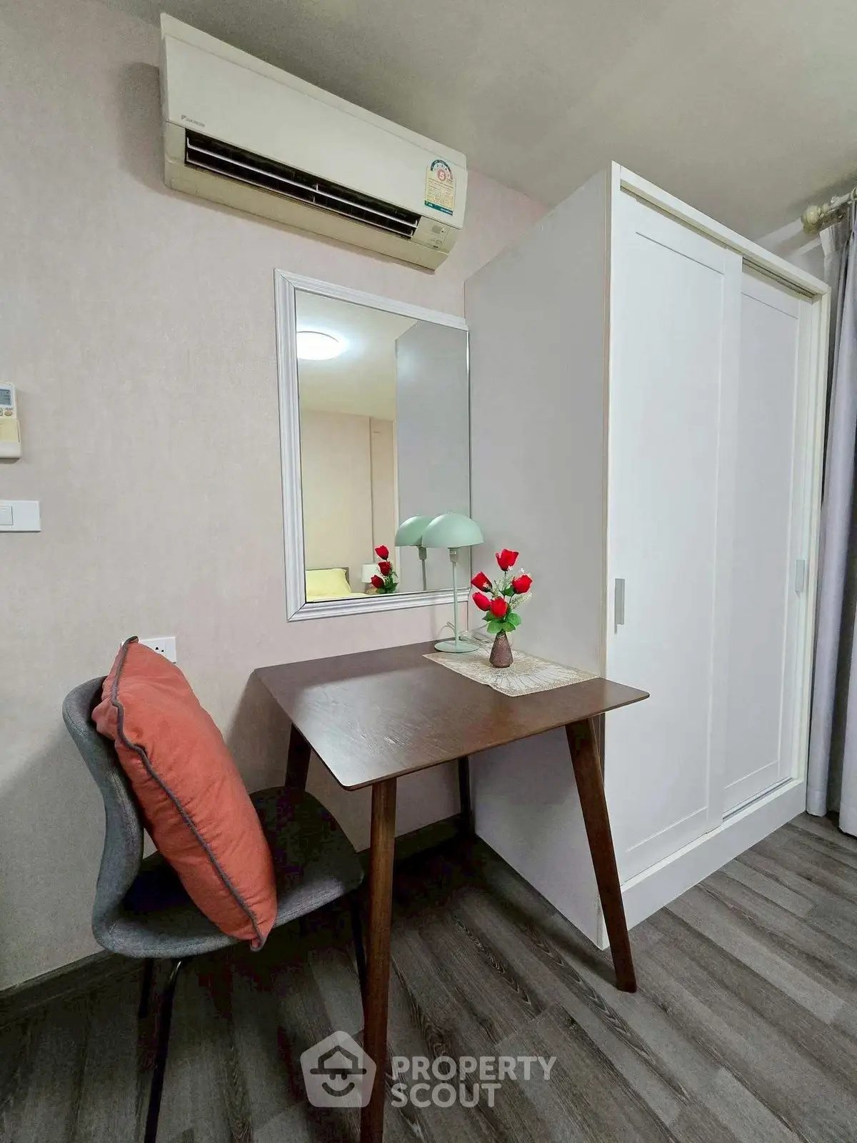 Cozy study nook with desk, chair, and mirror in modern apartment interior.