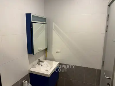 Modern bathroom with sleek vanity and mirror in a compact space.