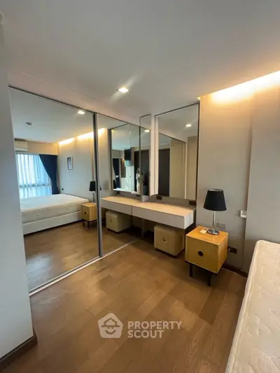 Spacious bedroom with mirrored closet and modern decor