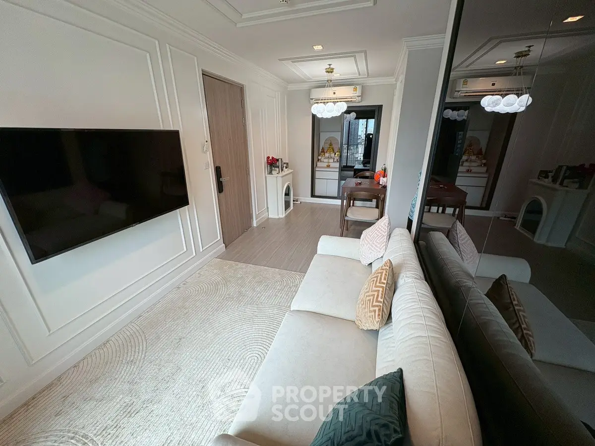 Elegant living room with modern decor and wall-mounted TV in a stylish apartment.