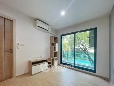 Bright living room with large window overlooking pool and modern wooden flooring.