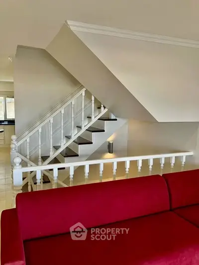 Elegant staircase with red sofa in modern home interior