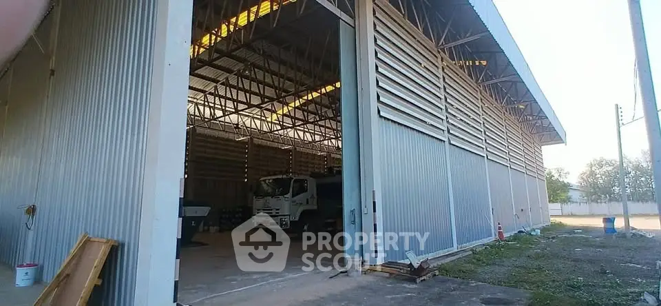 Spacious industrial warehouse with high ceilings and large open entrance, ideal for logistics and storage.