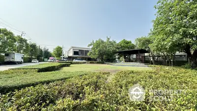 Spacious garden view with modern building and lush greenery