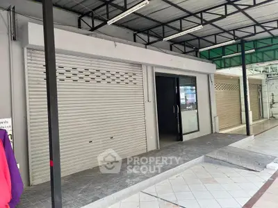 Commercial property with roller shutter doors and modern entrance in a prime location.