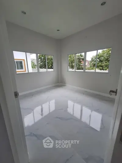 Bright empty room with large windows and glossy marble floor, perfect for customization.