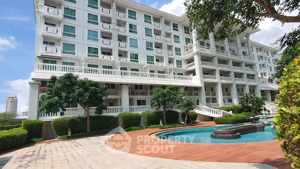 Luxurious apartment building with pool and lush greenery, perfect for modern living.