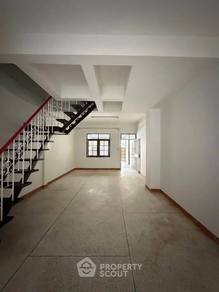 Spacious interior with elegant staircase and natural light, perfect for modern living.