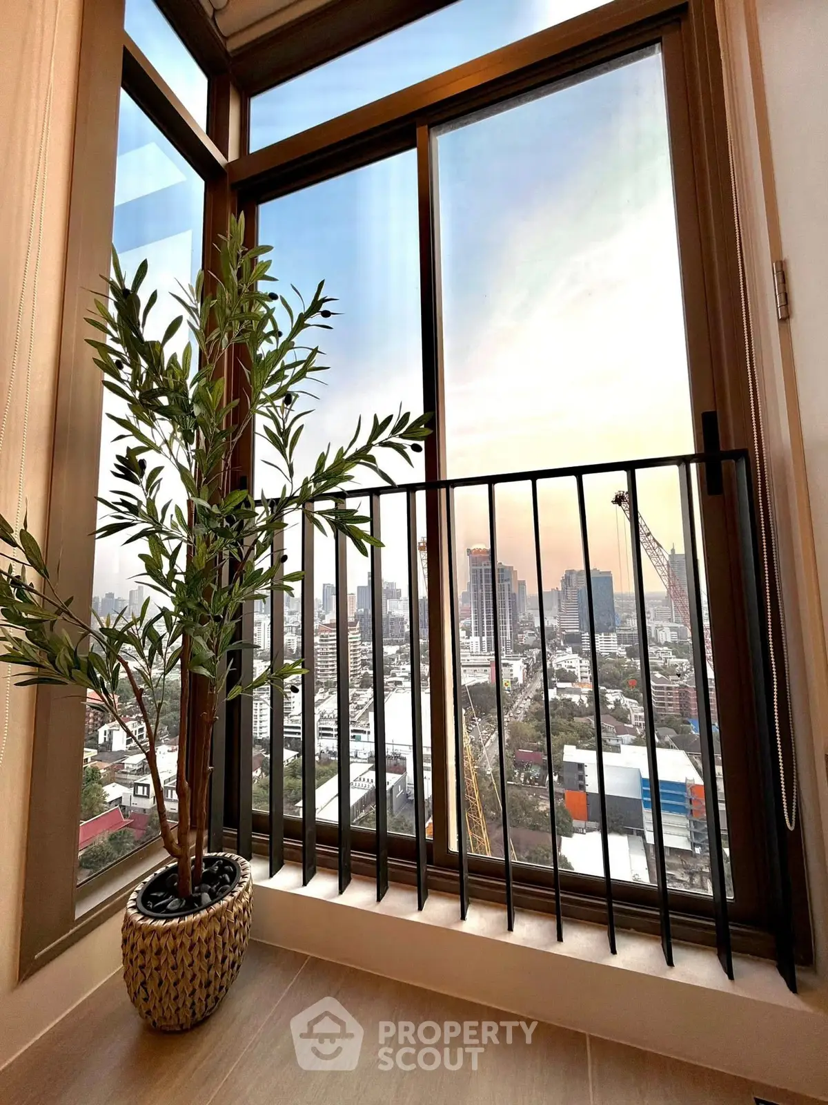 Stunning city view from a modern balcony with elegant potted plant.