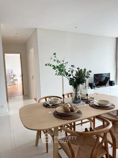 Modern dining area with elegant table setting and open view to living room