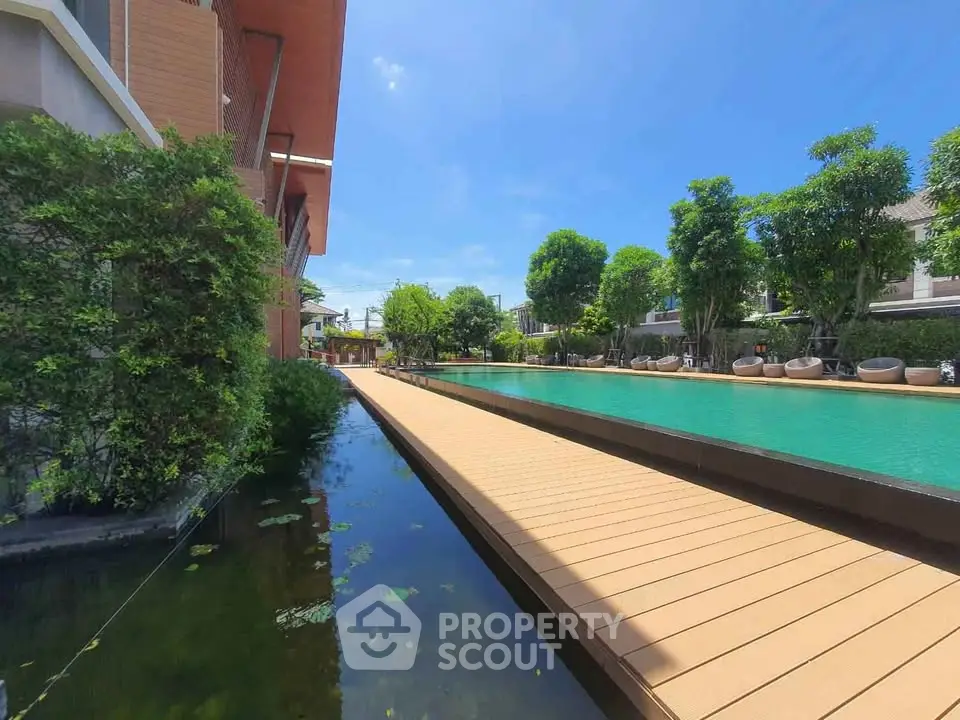 Luxurious residential pool area with lush greenery and modern design.