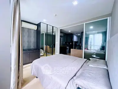 Modern bedroom with mirrored wardrobe and cozy bedding in stylish apartment.