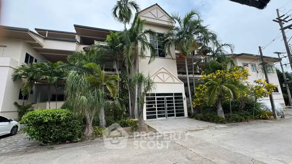 Elegant residential building with lush greenery and modern architecture.