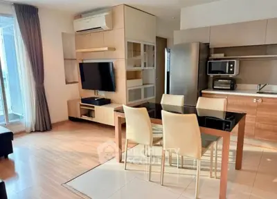 Modern open-plan living room and kitchen with sleek furniture and natural light.