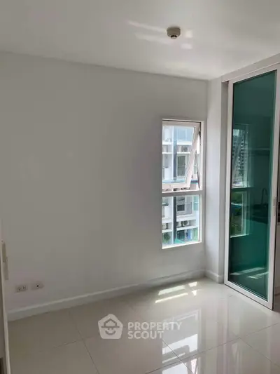 Bright empty room with large window and sliding glass door, ideal for customization.